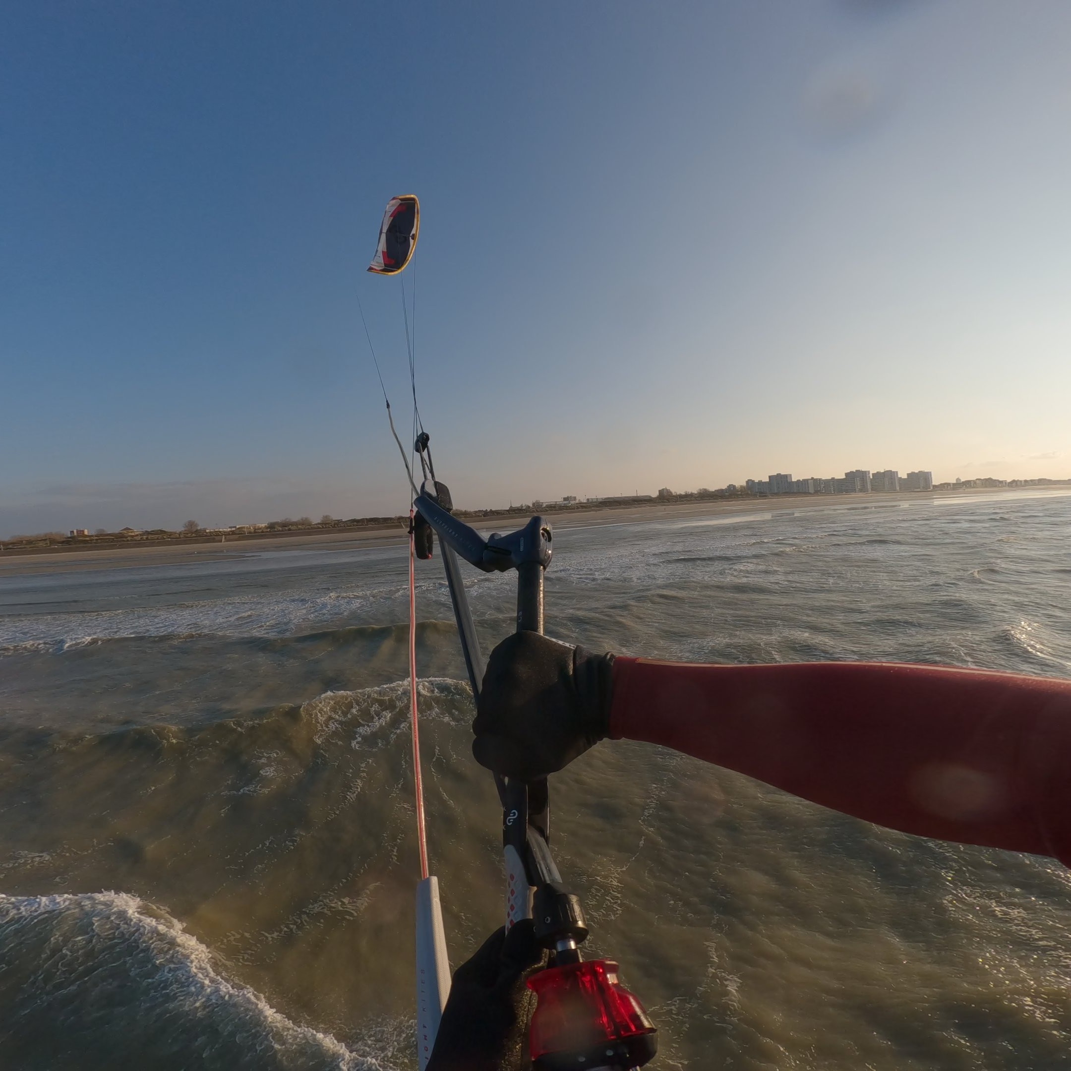 Rider en action sur une mer calme avec la barre de kite connectée à l’aile Eleveight RS PRO V1 2025 – contrôle précis et performance en kitesurf.